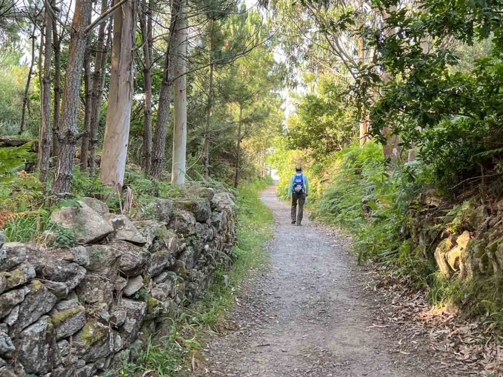 Camino Finesterre hiker and rock wall