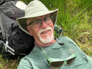 Napping on Camino Larocca-Pitts, autumn 2024 la concha, man in hat.